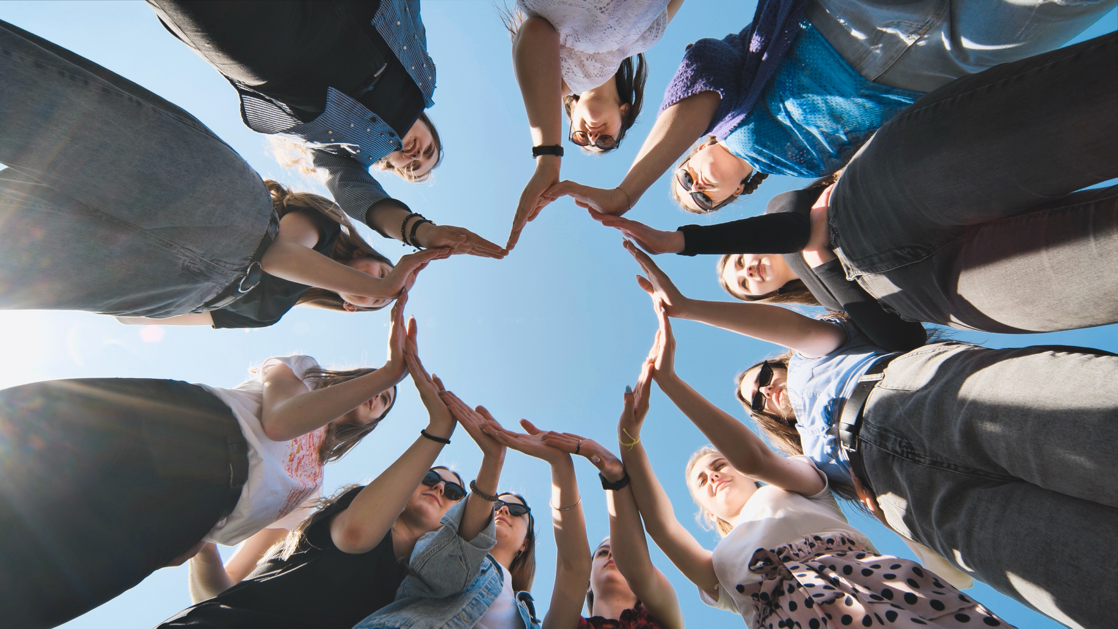 Women forming heart shape with hands